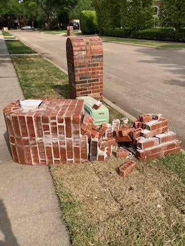 Broken mailbox made of red bricks on the roadside